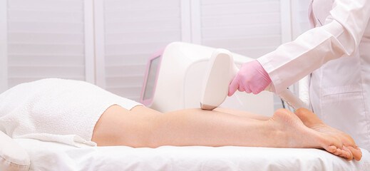 Obraz na płótnie Canvas Banner Diode laser hair removal, Beautician removes hair on beautiful female legs, Hair removal for smooth skin, laser procedure at beauty studio or clinic, Body care epilation treatment.