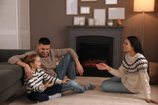 Happy Family Spending Time Together Near Fireplace At Home