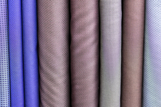 Purple, gray and blue bolts of fabric for making suits by a tailor