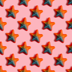 Fototapeta na wymiar Seamless pattern with jelly candy in the form of starfish on pink background.