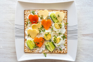 Matzah sandwich with cream cheese, fresh cucumber, bell pepper, thyme leaves, boiled eggs for...