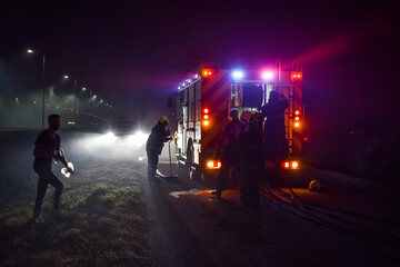 Bomberos trabajando en una autopista durante un incendio forestal con su camión. Fuego y llamas...