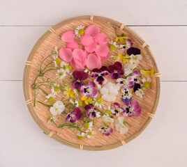 fresh edible flowers on a plate.
flower petals on white background.
