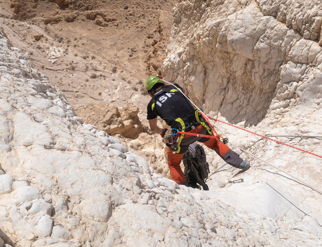 An experienced athlete starts the descent with the equipment for snapping in the mountains of the Judean Desert near the Tamarim stream near Jerusalem in Israel