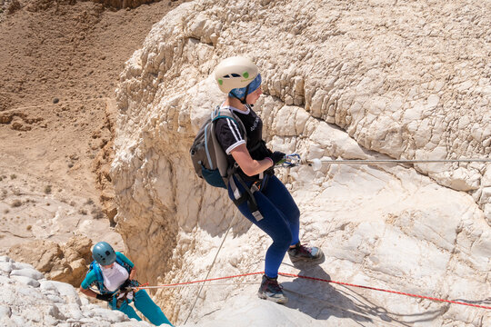 Experienced athletes start the descent with the equipment for snapping in the mountains of the Judean Desert near the Tamarim stream near Jerusalem in Israel