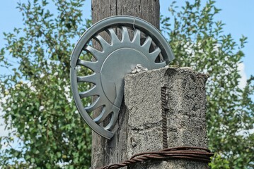 one gray plastic broken round cap for a car wheel on a concrete pole on the street against the...