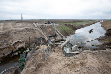 A blown up bridge and burnt out civilian cars in a place where the Russian and Ukrainian armies recently fought in Kyiv region, Ukraine