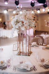 elegant high flower arrangement in the decor of the wedding banquet table