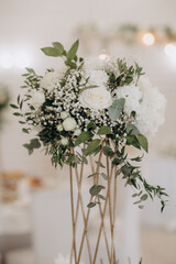 elegant high flower arrangement in the decor of the wedding banquet table