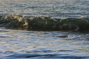 Fototapeta na wymiar sunlight reflected in the waves of the surf in the Northsea coast of Goeree Overflakkee