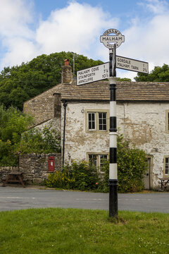 Signpost on the village green: Malham, Yorkshire Dales, North Yorkshire, England