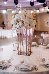 elegant high flower arrangement in the decor of the wedding banquet table