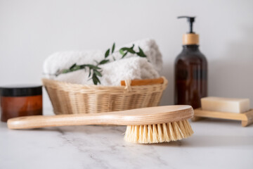 Massage wooden body brush on the background of spa items. Homemade body care. Dry lymphatic drainage massage and spa treatments. Cactus bristle brush