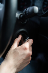 Fototapeta premium Person jams the car and takes the key out of the ignition. Safety in the car. Hand with key close-up