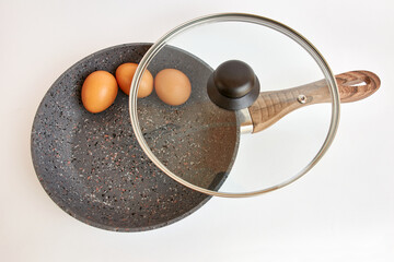 Cast iron frying pan with eggs on a white background.