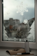 Beautiful drawing made with artificial snow on window at home. Christmas decor