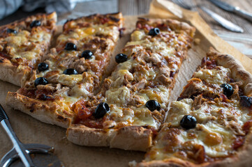 Pizza with tuna, onions, mozzarella , tomatoes and black olives. 