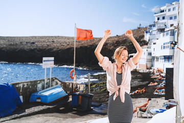 Fototapeta na wymiar Woman enjoys vacation on stone beach in Tufia small old village (like Santorini in Greece) in Gran Canaria, Spain. Tourist during summer holiday in authentic fishing town in Canary Islands