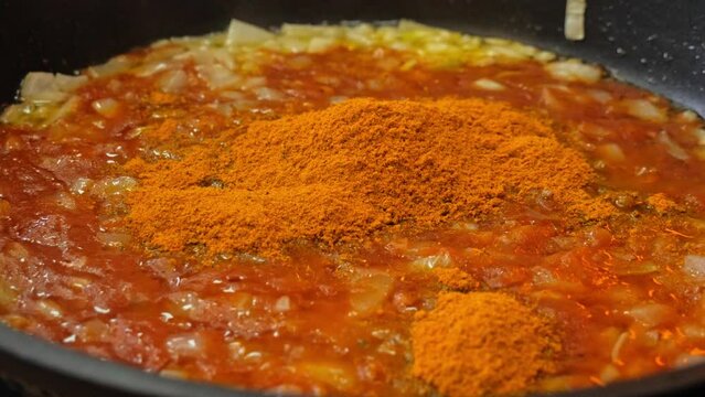 Ground turmeric will be added to fried onions in a pan
