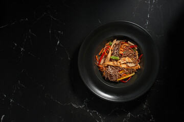 Top view, Soba beef and vegetables, Buckwheat noodles on a dark stone background. Asian cuisine, Wok menu.