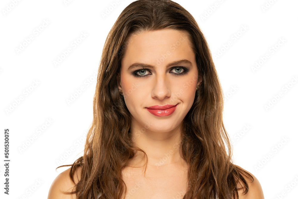 Wall mural Beautiful smiling woman with make up and wavy hair on a white background