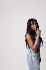 Beautiful African young woman with a thoughtful face posing indoor. Vertical.