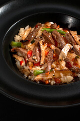 Chinese rice with beef meat and vegetagles on dark background