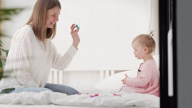 Little baby girl and mommy playing color wooden toys at home, Mother and daughter laughing having fun together, Early education