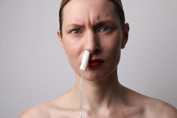 Young woman is holds a menstrual tampon. Intimate hygiene concept. Mock-up.