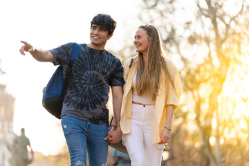 Young heterosexual couple walking in a park and talking