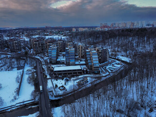 Aerial view of residental complex Novogorsk Olympic village in the evening at sunset. River like a border, beautiful view from the sky. 