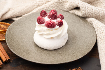 Meringue, meringue with raspberry dessert, on a wooden background.