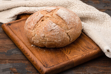 Bread, baguette, boton, rye on a wooden background.