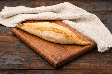 Bread, baguette, boton, rye on a wooden background.