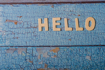 Hello word written on wooden letters text on a textured blue surface