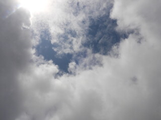 雲間に見える太陽と青い空