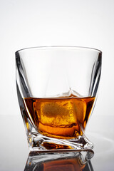 luxury whiskey in a crystal glass with reflection, isolated on white background