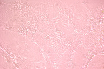 Transparent pink clear water surface texture with ripples, splashes and bubbles. Abstract nature...