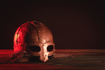 Ancient warrior helmet on the dark table background with copy space. Front view.
