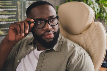 Portrait of attractive successful skilled guy geek expert technician touching specs at workplace...