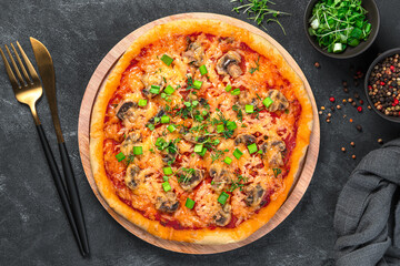 Homemade pizza with cheese, mushrooms, tomatoes and fresh herbs on a dark background. Vegetarian food. Top view, close-up.
