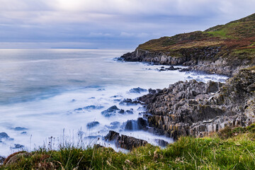 Looking down from one headland towards the next, with dramatic rocks of the cove in between.  A long exposure brings a dreamy quality.