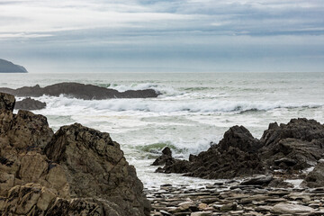 The waves roll in towards the many rocks and stones on this beautiful North Devon beach on a cold November day.