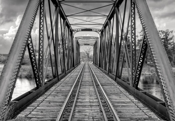 Old iron railway truss bridge built in 1893 crossing the Mississippi river in spring in Galetta,...