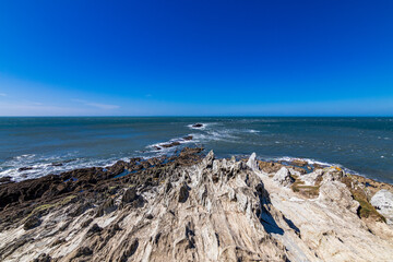 Across the rocks at Morte Point, looking out towards the sea.  A crystal clear blue sky on a bright April day.