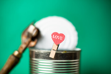 Former, forgotten love concept. Heart with the inscription love on the background of an open tin...