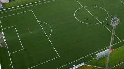 Aerial view on an artificial turf soccer field while some players are engaged in a match