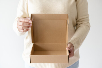 Woman hands carrying brown opening cardboard box. Concept of using recycle paper box.