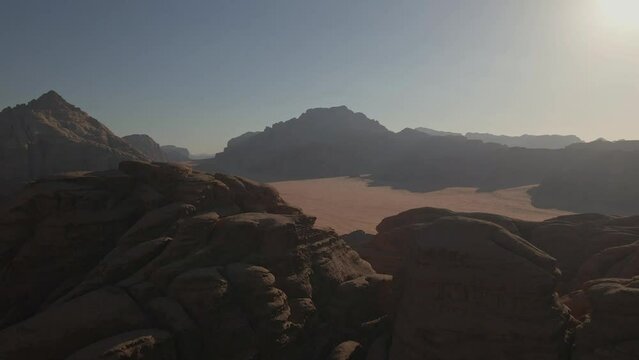 drone image looking down over a mountain range on the sand in the wadi rum desert