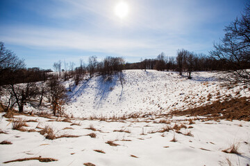 Winter nature landscape. Snow-covered fields and hills. Beautiful winter sunny day. Rural landscape.	